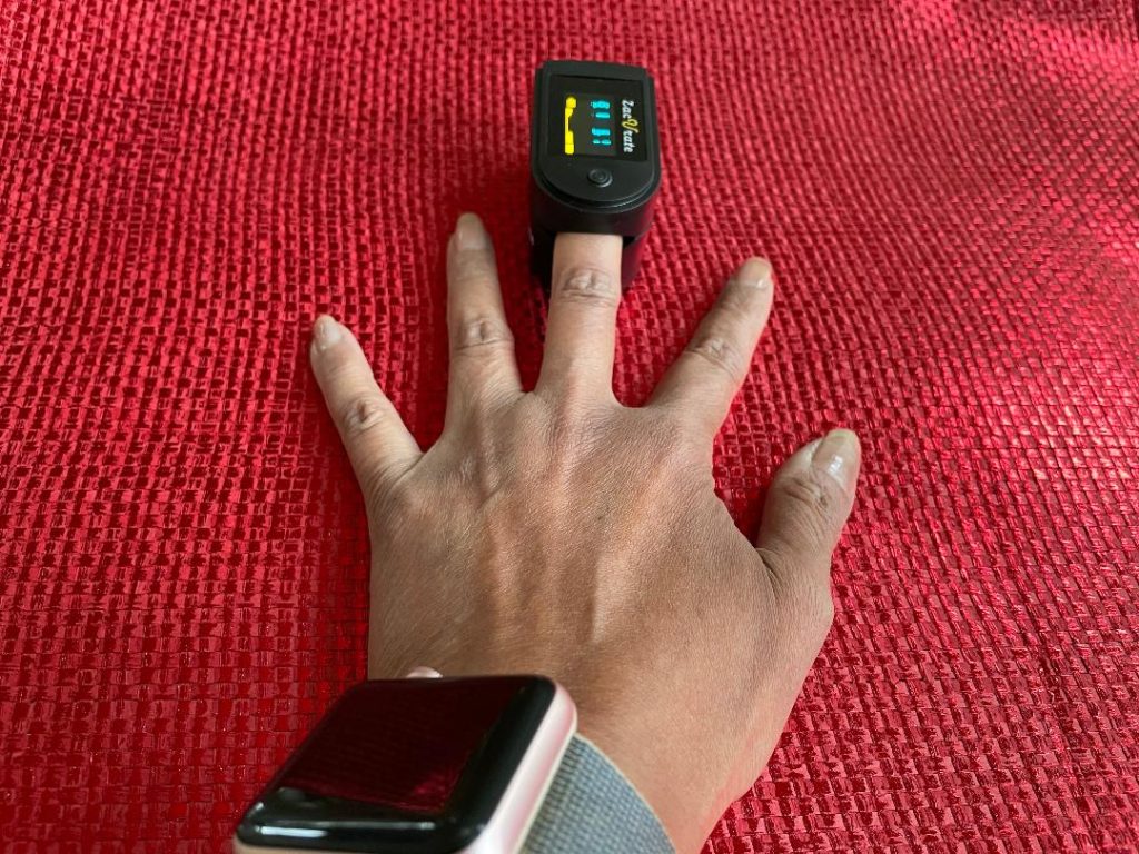 Finger pulse oximeter on a brown hand